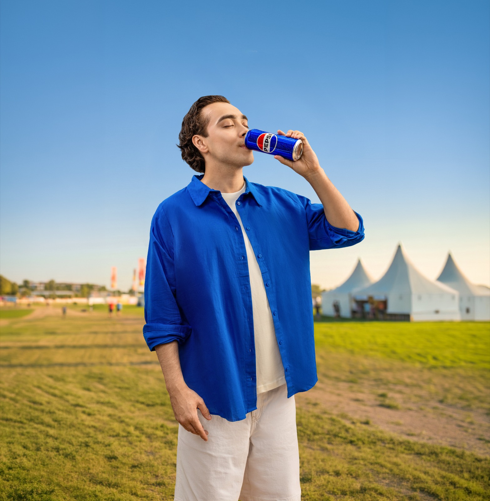 Парень пьёт Pepsi на фестивале